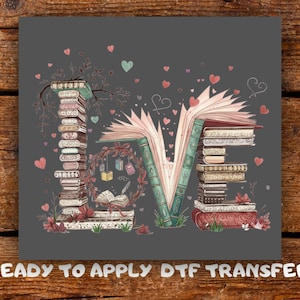 May include: A grey graphic with the word "LOVE" created from books, open pages, and floral details. Pink and teal hearts are scattered around the letters. The text "READY TO APPLY DTF TRANSFER" is at the bottom.