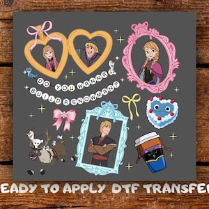May include: A gray DTF transfer sheet featuring cartoon characters from Frozen, including Anna, Elsa, Kristoff, Sven, and Olaf. The design includes gold heart frames, a pink ornate frame, a blue frame, a heart-shaped cake, and the text DO YOU WANNA BUILD A SNOWMAN?