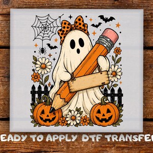 Peut inclure: Une illustration de fantôme blanc portant un nœud à pois orange et noir, tenant un grand crayon orange avec une pancarte en bois vierge. Le motif comprend deux citrouilles d'Halloween, des marguerites blanches, une toile d'araignée et des chauves-souris.