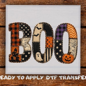 May include: A ready to apply DTF transfer featuring the word BOO in a patchwork style. Each letter is composed of various Halloween-themed patterns including orange and black buffalo plaid, spider webs, bats, ghosts, pumpkins, and stars.