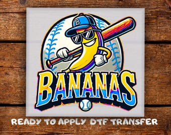 May include: A colorful graphic featuring a smiling banana wearing sunglasses and a baseball cap, holding a baseball bat. The word "BANANAS" is displayed in large, stylized letters. A baseball is at the bottom. The text "READY TO APPLY DTF TRANSFER" is at the bottom.
