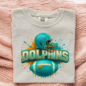 Transferencia DTF de fútbol con casco verde azulado, balón Splash Dolphin Team Spirit, listo para prensar, impresión adorable del día del partido en Miami para prensa de calor deportiva. Without Logo