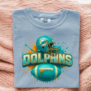 Transferencia DTF de fútbol con casco verde azulado, balón Splash Dolphin Team Spirit, listo para prensar, impresión adorable del día del partido en Miami para prensa de calor deportiva. With Logo