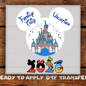 May include: A light gray square with a colorful graphic featuring a castle, stars, and the words "Family Trip Vacation." The year "2026" is displayed with Mickey Mouse-themed numbers. The text "READY TO APPLY DTF TRANSFER" is at the bottom.