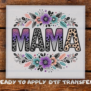 May include: A square design featuring the word "MAMA" in bold, leopard-print letters, surrounded by floral and leaf accents in shades of purple, pink, and teal. The text "READY TO APPLY DTF TRANSFER" is at the bottom.