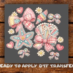 May include: A collection of watercolour bows, hearts, and flowers in shades of pink, blue, and yellow on a grey background. The design includes a starfish and the text "READY TO APPLY DTF TRANSFER".