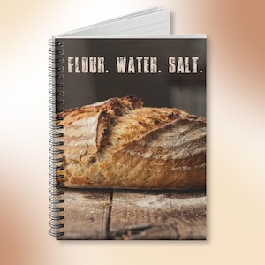 May include: Spiral-bound notebook with a cover featuring a loaf of bread on a wooden surface. The text "FLOUR. WATER. SALT." is printed at the top. The bread is golden brown with a textured crust, suggesting a rustic style. The notebook is ideal for culinary enthusiasts.