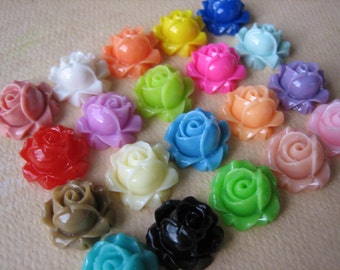 May include: Assortment of 20 colorful resin rose flower cabochons. The roses are in various colors, including pink, blue, green, yellow, red, white, and black.