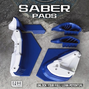 May include: A collection of blue and white protective pads, with the words "SABER PADS" displayed at the top. The pads are arranged on a grey concrete surface. The text "UNLOCK YOUR FULL LEAN POTENTIAL" is at the bottom.