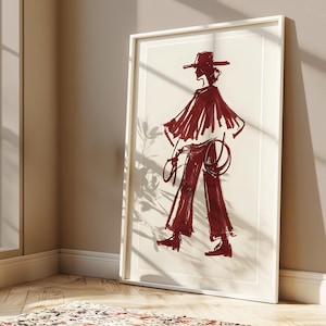 May include: A framed illustration of a person wearing a wide-brimmed hat and a long, flowing garment. The illustration is done in shades of red and white.