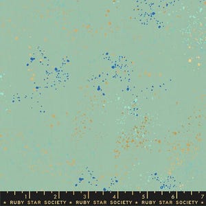 May include: A fabric with a light green background and a speckled pattern of blue, orange, and white dots. The bottom of the image has a ruler with the text "RUBY STAR SOCIETY".