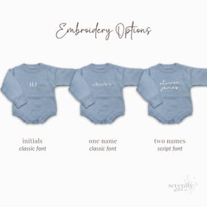 May include: Three light blue long-sleeve knit rompers displayed horizontally. The text Embroidery Options appears at the top. Each romper features different embroidery: HJ in a classic font, charles in a classic font, and oliver james in a script font.