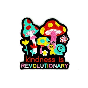 May include: Embroidered patch featuring colorful mushrooms, flowers, a snail, and a butterfly. The patch has the text "kindness is REVOLUTIONARY" in a vibrant font. The design is set against a black background.