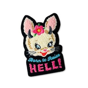 May include: Embroidered patch featuring a cartoon-style bunny face with horns, a pink flower crown, and the text "Born to Raise HELL!" in pink and blue. The patch has a black border and a cream-colored face.