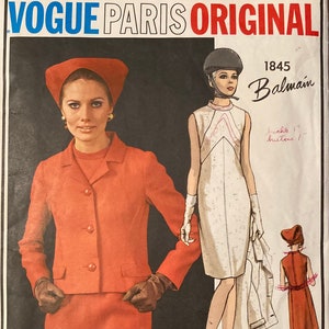 May include: A vintage Vogue Paris Original sewing pattern. The image shows a woman in a red suit and a drawing of a white dress. The pattern is labelled "1845 Balmain" with red and blue text.