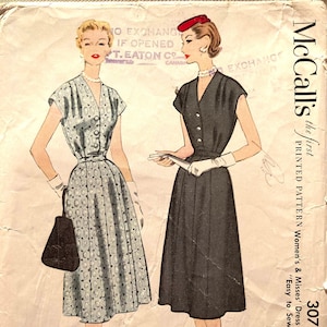 May include: Vintage McCall's sewing pattern for a dress, size 20 1/2, bust 41 inches. The pattern is for half sizes and is labelled "Easy to Sew". The pattern shows two women wearing the dress, one in a light blue print and the other in black.