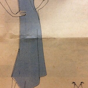 Puede incluir: Un vestido azul sin mangas con escote en V y un lazo en los hombros. El vestido tiene un corpi&ntilde;o ajustado y una falda fluida. La parte posterior del vestido se muestra con un simple escote en V.