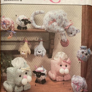Peut inclure: Un patron de couture Simplicity Crafts pour réaliser des housses de boîte à mouchoirs en forme d'animaux. Le patron comprend un chat, un chien, un mouton et un cochon. Le patron est pour une seule taille et est imprimé sur un fond blanc avec un cœur rose et les mots "Simplicity Crafts".
