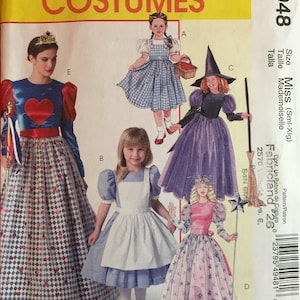 May include: A sewing pattern for five different children's costumes. The costumes include a witch, a queen of hearts, a Dorothy from the Wizard of Oz, Alice in Wonderland, and a princess. The pattern is from McCall's Costumes and is size Miss (Sml-XIg).