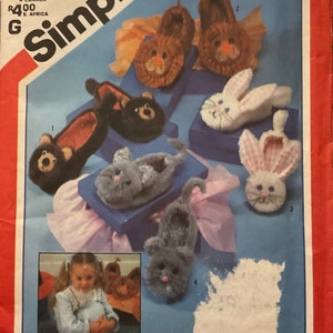 May include: Simplicity sewing pattern number 6231 for adults. The pattern includes instructions for making five pairs of animal-themed slippers. The slippers feature a lion, bear, bunny, and cat design. The pattern is shown on a blue background with a white border.
