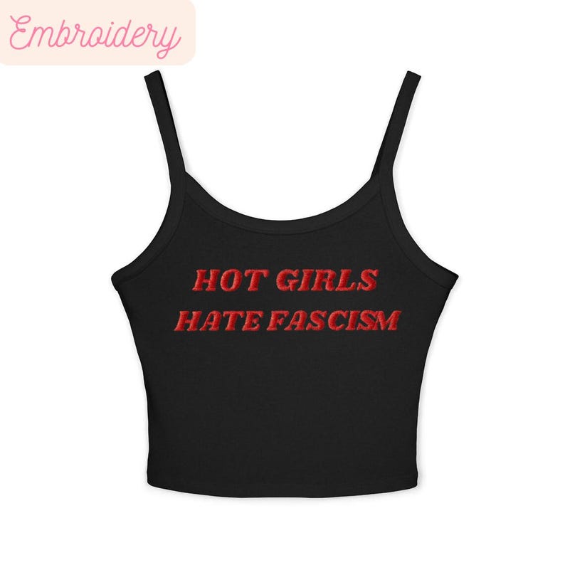 May include: Black camisole top with thin straps. The words "HOT GIRLS HATE FASCISM" are embroidered in red across the front. A casual garment.