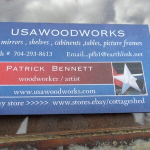 May include: A blue and red business card with the text "USAWOODWORKS" in white. The card lists services such as mirrors, shelves, cabinets, tables, and picture frames. It also includes the name "PATRICK BENNETT" and the text "woodworker / artist". The card includes contact information such as a phone number, email address, website, and an eBay store link.