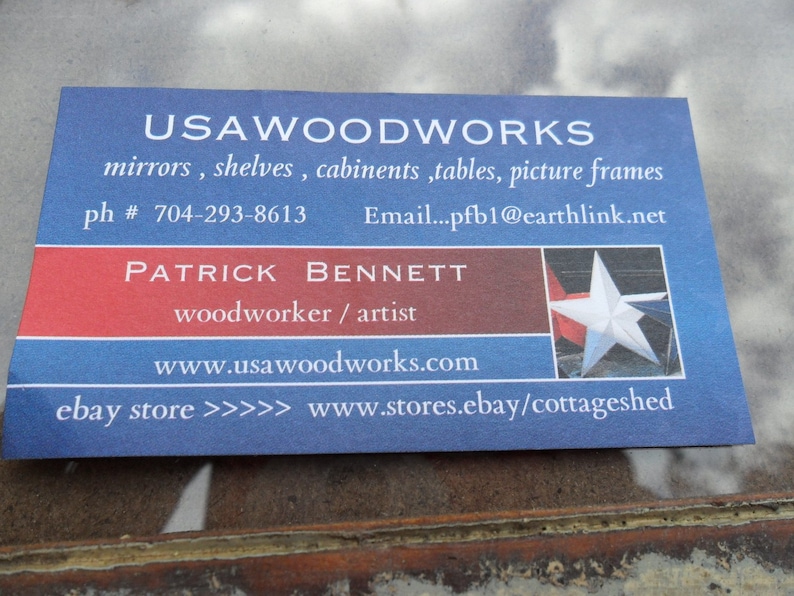 May include: A blue and red business card with the text "USAWOODWORKS" in white. The card lists services such as mirrors, shelves, cabinets, tables, and picture frames. It also includes the name "PATRICK BENNETT" and the text "woodworker / artist". The card includes contact information such as a phone number, email address, website, and an eBay store link.
