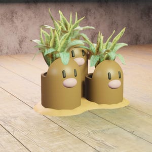 May include: Three brown, cartoon-style planters shaped like Diglett characters, each holding a green plant with long, pointed leaves. The planters sit on a sandy-colored base, with a light brown wooden floor in the foreground.