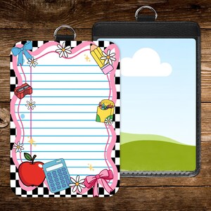 May include: Two ID badge holders. One features a lined paper design with school-themed illustrations like an apple, pencil, and calculator, framed in pink and black checkered borders. The other is a black leather-like holder with a landscape image.