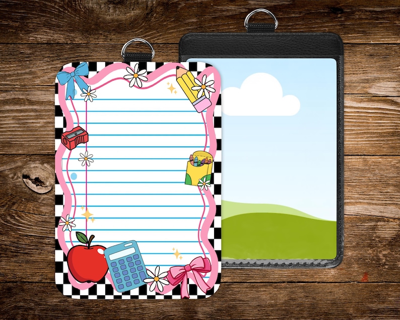 May include: Two ID badge holders. One features a lined paper design with school-themed illustrations like an apple, pencil, and calculator, framed in pink and black checkered borders. The other is a black leather-like holder with a landscape image.