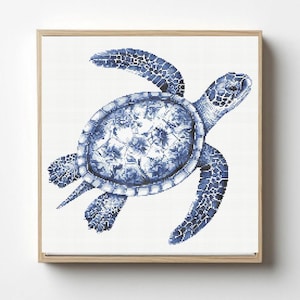 May include: A square framed cross-stitch pattern featuring a sea turtle rendered in various shades of blue and white. The turtle is depicted in a swimming motion with a detailed shell pattern and textured flippers, set against a white background.