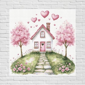 May include: A cross-stitch design of a charming white house with a pink roof and door, surrounded by pink flowering trees and hearts. A stone path leads to the house, with flowers and greenery.