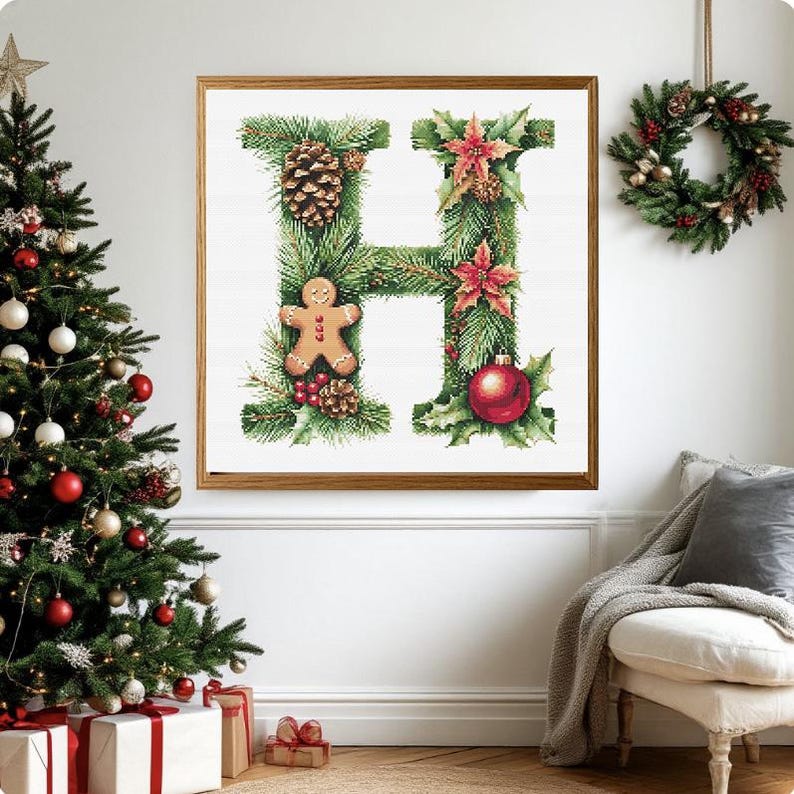 May include: A framed Christmas-themed artwork featuring the letter "H" decorated with pine needles, pine cones, a gingerbread man, red berries, and a red ornament. A Christmas tree and wreath are also visible.