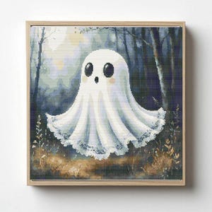 May include: A square framed cross-stitch pattern featuring a white ghost with large black eyes and pink cheeks. The ghost is centered against a dark, moody forest background with tall trees and a glowing light source behind the figure.