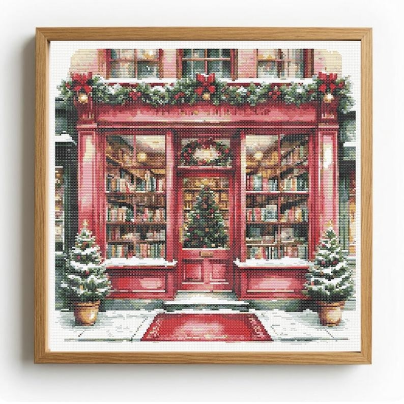 May include: A framed cross-stitch embroidery depicting a red storefront with large glass windows filled with bookshelves. The exterior is decorated with green garlands, red bows, and two potted Christmas trees flanking the entrance door.