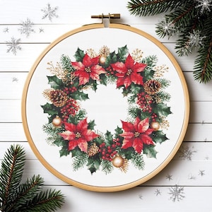 Könnte beinhalten: Ein Kreuzstich-Weihnachtskranz mit roten Weihnachtssternen, grünem Stechpalmen, Tannenzapfen und goldenen Ornamenten. Der Kranz wird in einem hölzernen Stickrahmen präsentiert. Festliche Weihnachtsdekoration.