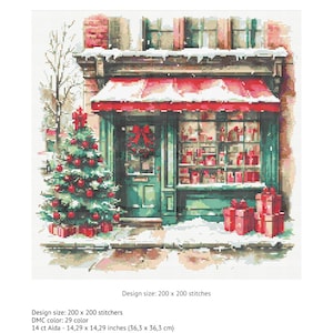 May include: A cross stitch chart titled Christmas shop window featuring a storefront with a red awning, a decorated Christmas tree, and wrapped gifts. The design size is 200 by 200 stitches, with dimensions of 14.29 by 14.29 inches on 14 count Aida fabric.