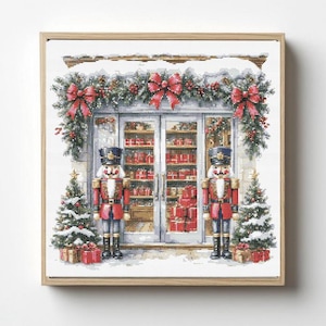 May include: A cross-stitch pattern featuring a storefront decorated for the holidays with two nutcrackers standing guard. The scene includes snow-covered evergreen garlands, red bows, two small Christmas trees, and a shop window filled with red gift boxes.