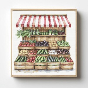 Op de afbeelding: Een kruissteekpatroon met een marktkraam met een rood-wit gestreepte luifel. De houten planken zijn gevuld met kratten vol diverse groenten, waaronder tomaten, komkommers, aubergines en bladgroenten in een rasteropstelling.