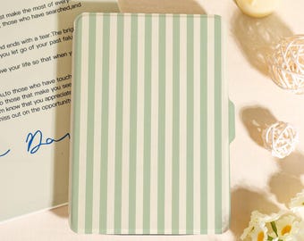 May include: A light green and white striped notebook or journal. The cover features vertical stripes and a small tab on the right side. The notebook is closed and appears to be new.