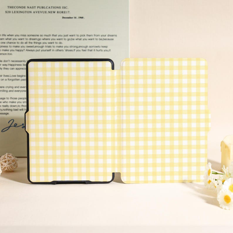 May include: A yellow and white gingham pattern tablet case, open to display the interior. The case is set against a backdrop of a letter with text. The case is designed to protect a tablet.