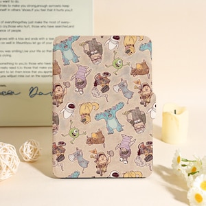 Può includere: Una custodia per tablet color cachi con un motivo ripetuto di personaggi dei cartoni animati in vari colori. I personaggi includono un mostro blu, un ciclope verde e altre figure animate.