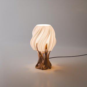 May include: A table lamp featuring a white, translucent, wavy, ribbed shade that emits a soft glow. The base is constructed from a dark brown, organic, branching structure that supports the shade from below, connected by a black power cord.