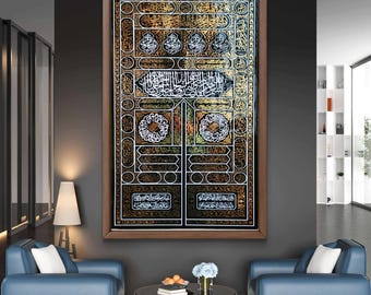 Puede incluir: Una obra de arte enmarcada con intrincada caligrafía dorada y negra. La obra de arte representa un diseño detallado con patrones ornamentados y escritura árabe. El marco es de color marrón cálido, y la obra de arte se exhibe en un espacio de vida moderno con sillones azules.
