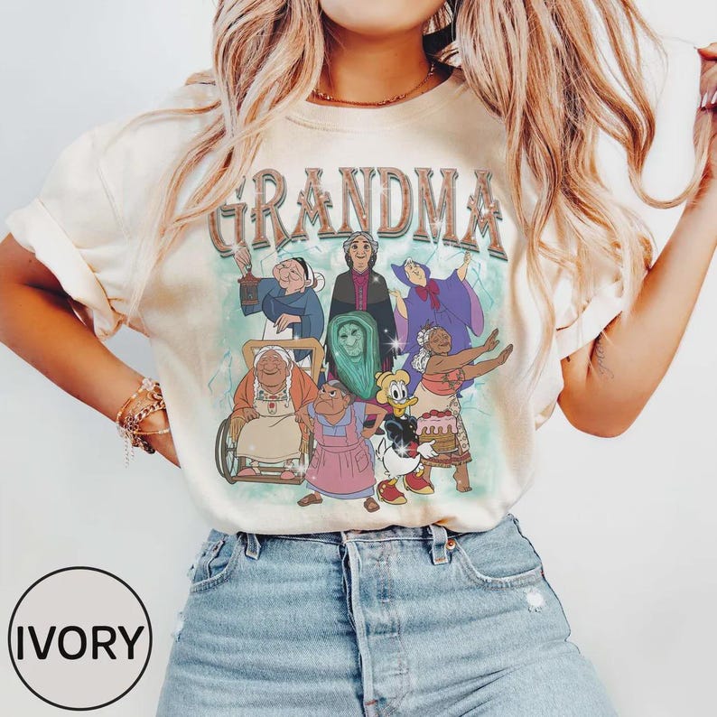 Puede incluir: Camiseta de color marfil con la palabra "GRANDMA" sobre un gr&aacute;fico de abuelas animadas. El gr&aacute;fico incluye personajes de varios colores. La camiseta se combina con pantalones cortos de mezclilla azules.
