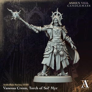 May include: A gray miniature figurine of a hooded figure wearing ornate armor and a sun-shaped headpiece. The figure holds a spiked mace-like staff in one hand and features hanging accessories at the waist. Text reads Ashen Veil Candlemass.