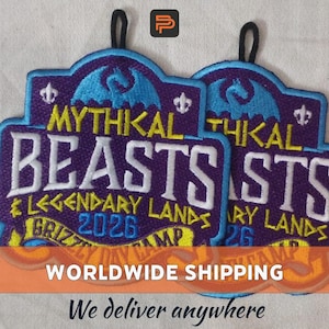 May include: Two embroidered patches with the text "MYTHICAL BEASTS" and "LEGENDARY LANDS 2026". The patches are purple with blue and yellow accents, and have a black loop at the top. The patches are likely for a camp or event.