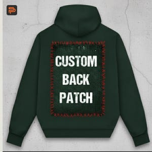May include: Dark green hoodie with a hood and long sleeves. The back features a rectangular patch with the words "CUSTOM BACK PATCH" in white block letters. The patch is outlined with red stitching.