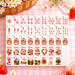 May include: A set of white mahjong tiles arranged in a grid, featuring pink and red strawberry-themed illustrations. The tiles display numbers one through nine, flower motifs, and special character tiles labelled Joker, N, S, W, E, Red, Soap, and Green.