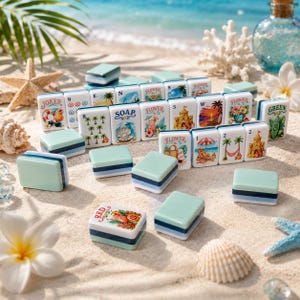 K&ouml;nnte beinhalten: Eine Sammlung dekorativer Mahjong-Steine und passender Boxen mit Strandmotiven. Die Steine zeigen Bilder von Blumen, Palmen und Strandszenen. Die Boxen sind hellgr&uuml;n mit blauen Streifen. Der Hintergrund zeigt Sand, Muscheln und Meer.